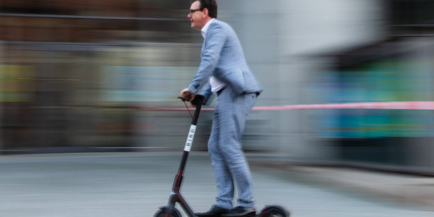 Ein Mann fährt mit einem Elektro-Roller, einem sogenannten «E-Scooter»