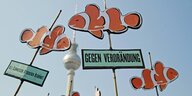 Bei einer Dmeonstration gegen drastisch steigende Mieten in Berlin werden Schilder mit Fischen und der Aufschrift „Gegen Verdrängung“ in die Höhe gehalten
