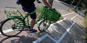 ein Fahrrad auf einem Radwer, der im. Zickzack um Baumscheiben herumgeht