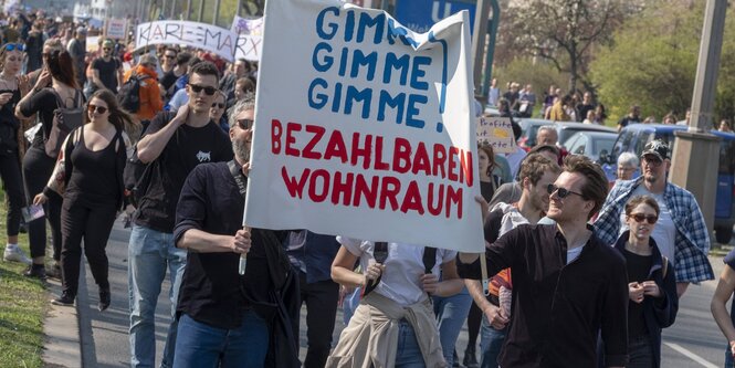 Protestierende Menschen halten Plakate hoch: „Gimme, gimme, gimme! Bezahlbaren Wohnraum“