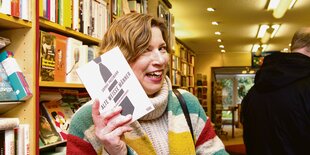 Jenneke de Vries hält ein Buch mit dem Titel "Alte weiße Männer" in der Hand.