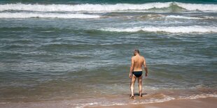 Mann mit schwarzer Badehose am Strand