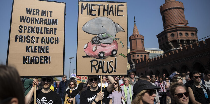 2 junge Männer tragen Schilder auf der Mietendemo