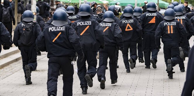 Eine Gruppe Polizisten rennt durch eine Stadt