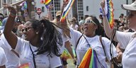 Eine Gruppe von Frauen tanzt mit bunten LGBTQI-Flaggen und -Fächern