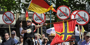 Menschen mit Deutschlandfahnen und Anti-Moschee-Plakaten bei einer Kundgebung