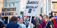 Als Kuh verkleideter Demonstrant mit Schild: "Scheiß Buuulln"