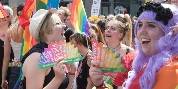 Frauen mit Regenbogenfahnen feiern auf dem Christopher Street Day