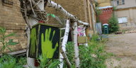Ein grüner Handabdruck an einem Zaun aus Birkenholz