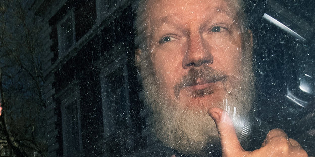 Julian Assange zeigt seinen Daumen