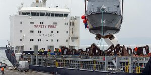 Patrouillenboot wird auf Transportschiff verladen
