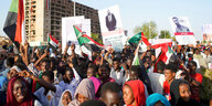 Menschen mit sudanesischen Flaggen und Plakaten demonstrieren in Khartum