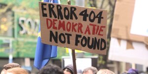 Bei einer Demo wird ein Schild mit der Aufschrift: „Error 404 Demokratie not found“ hochgehalten