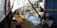 Menschen liegen aneinandergedrängt auf dem Deck eines schiffes