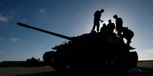Vier Männer stehen auf einem Panzer