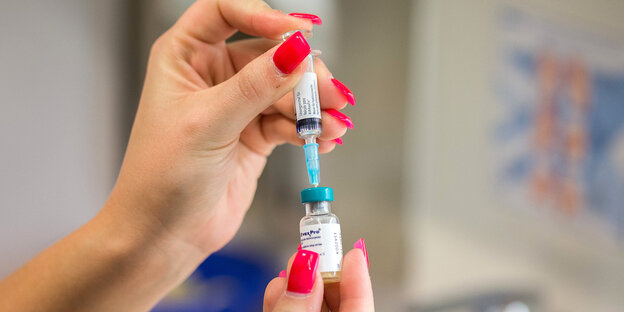 Frau mit lackierten Fingernägeln bereitet eine Impfung vor