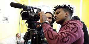 Zwei junge Männer bedienen eine Kamera.