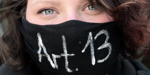 Frau mit schwarzer Vermummung - darauf steht „Artikel 13“