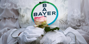 Protest: verkleidete Braut und Bayer-Logo