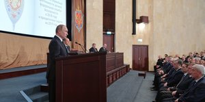 Putin spricht von einem Podium aus zu im Publikum sitzenden Geheimdienstlern