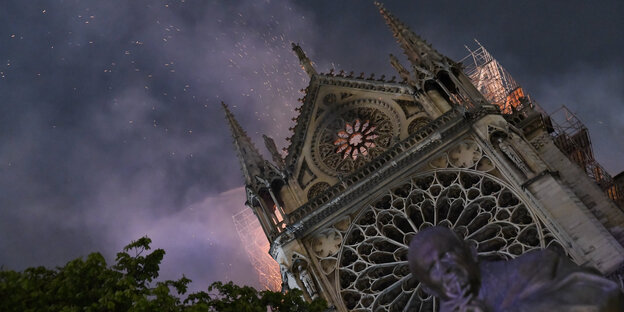 Funken fliegen über einer Kathedrale, aus der Feuer austritt