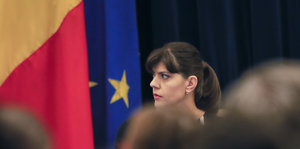 Die rumänische Korruptionsjägerin Kövesi steht vor Publikum vor der rumänischen und der EU-Fahne