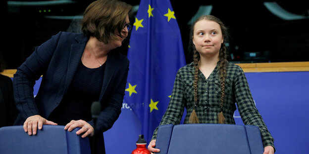 Greta Thunberg steht vor einem Stuhl im EU-Parlament