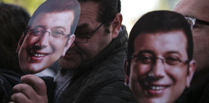 Menschen tragen Masken vom Oppositionskandidaten Ekrem Imamoglu