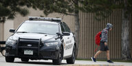 Ein Polizist hilft bei der Evakuierung der Columbine Highschool