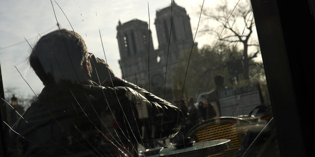 Ein Mann trinkt Kaffee und schaut auf Notre Dame