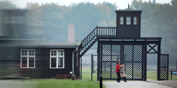 Besucher stehen vor dem ehemaligen Konzentrationslager Stutthof