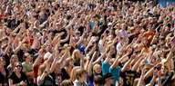 Evangelikale stehen in einer Menschenmenge und heben die Hände