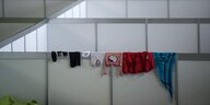 Kinderkleidung hängt zum trocknen über eine Trennwand in einem Hangar im Flughafen Tempelhof, der als Notunterkunft für Flüchtlinge dient