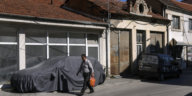 Ruhige Straße mit kleinem Haus und abgedecktem Auto