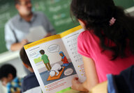 in Mädchen liest an der Robert-Koch-Schule während des islamischen Religionsunterrichts in einem Schulbuch.