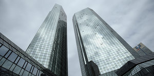 Die Hochhäuser der Deutschen Bank von unten nach oben fotografiert, dahinter grauer Himmel
