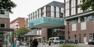 Menschen stehen vor dem Haupteingang des Universitätsklinikums Hamburg-Eppendorf (UKE).