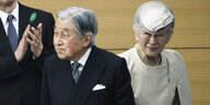 Der japanische Kaiser, ein alter Mann in Anzug und Krawatte mit der Kaisierin, einer alten Frau in einem weißen Kostüm mit Hut auf
