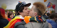 Zwei junge Männer küssen sich.