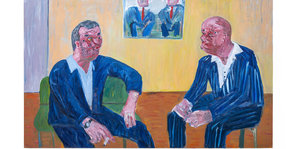 Zwei Männer in blauen Anzügen sitzend im Gespräch