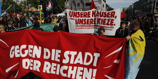 Demonstranten halten ein Transparent mit der Aufschrift "Geen die Stadt der Reichen"