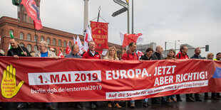 Menschen auf einer Demonstration hinter einem Leittransparent