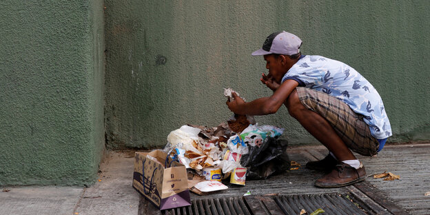 Ein Mann durchsucht Müll nach Essensreste