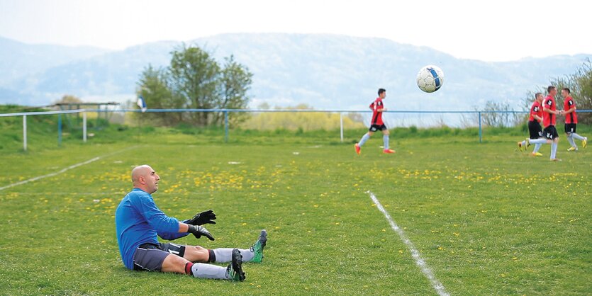 Torwart Patrik Herak sitzt auf dem Boden eines Fußballplatzes.