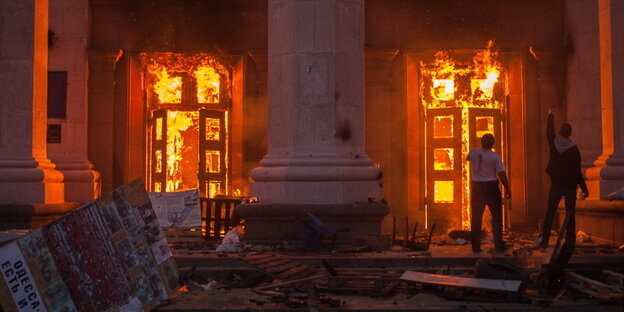 Flammen schlagen durch die Türen eines Gebäudes