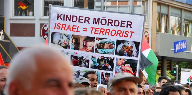 Demonstranten halten Schild mit der Aufschrift: Israel gleich Terrorist