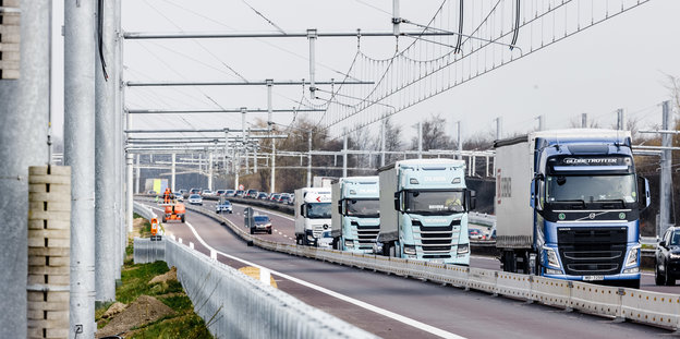 Lastwagenkolonne auf der Autobahn neben der künftigen Oberleitungsspur