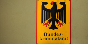 Auf der Plaktette des Bundeskriminalamts in Wiesbaden ist ein Bundesadler auf gelbem Grund zu sehen