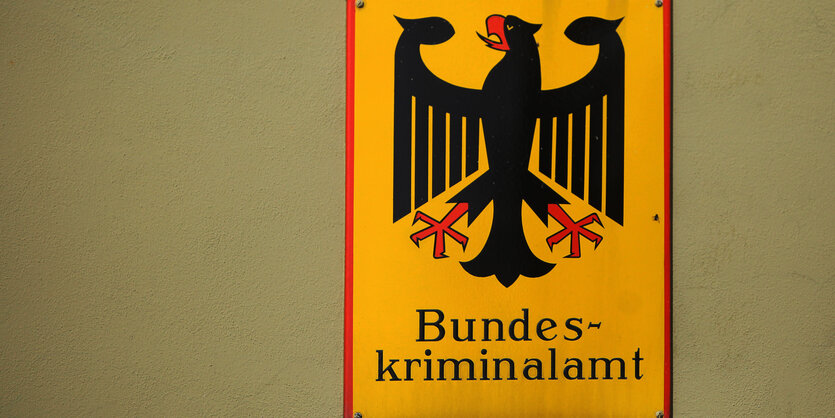 Auf der Plaktette des Bundeskriminalamts in Wiesbaden ist ein Bundesadler auf gelbem Grund zu sehen