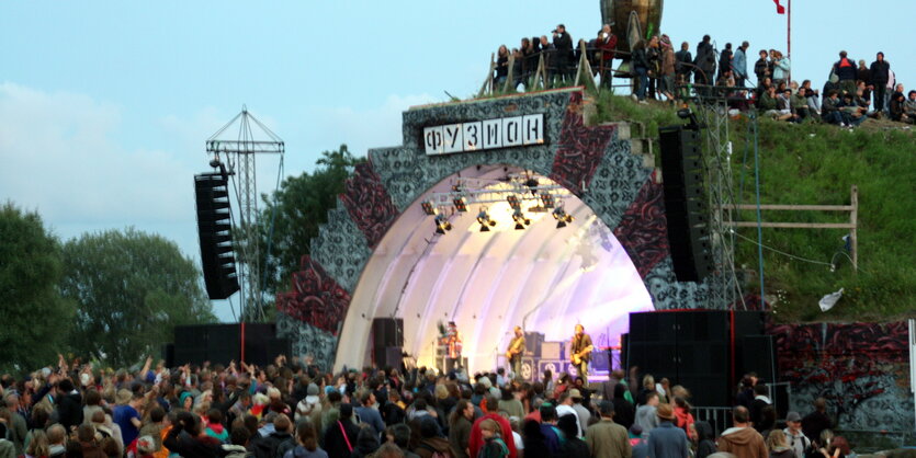 Eine beleuchtete Festivalbühne, davor Zuschauer